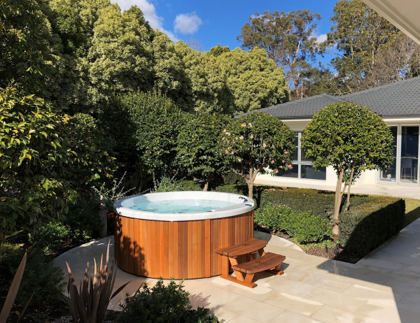 A smaller hot tub with minimal, idyllic surrounds and lots of greenery.