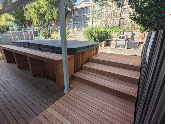 Spa in backyard with bench and deck